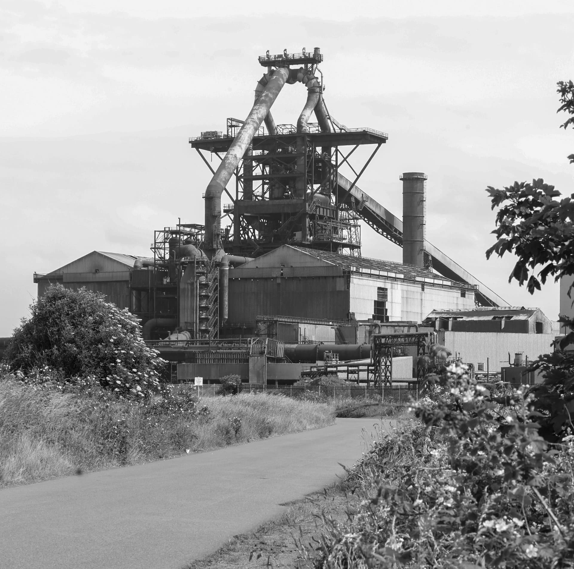 British Steel blast-furnace standing tall behind the approach road — the kind of operational refractory asset GNAT UK is brought in to strip during outage windows