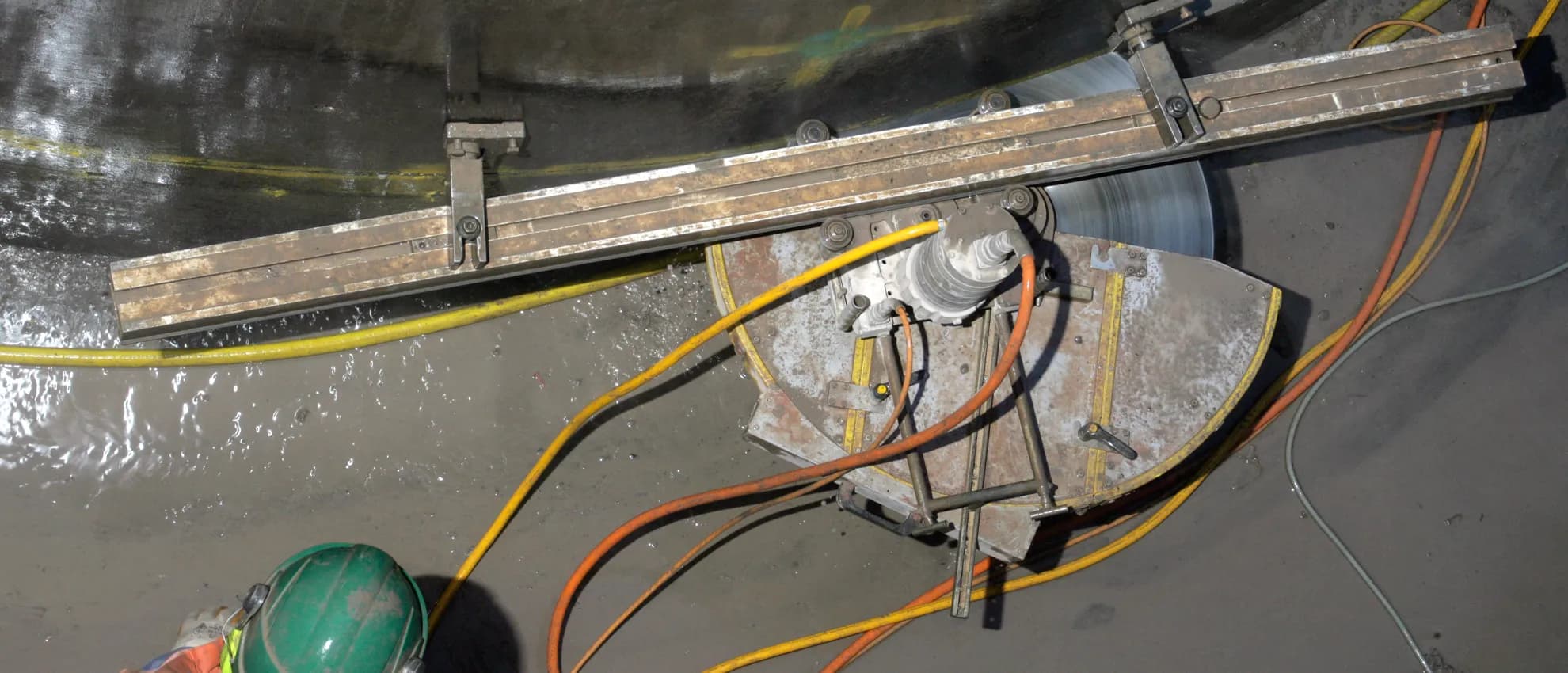 HILTI track saw operating inside a water-industry vortex chamber — top-down view of the cutting setup on concrete structure