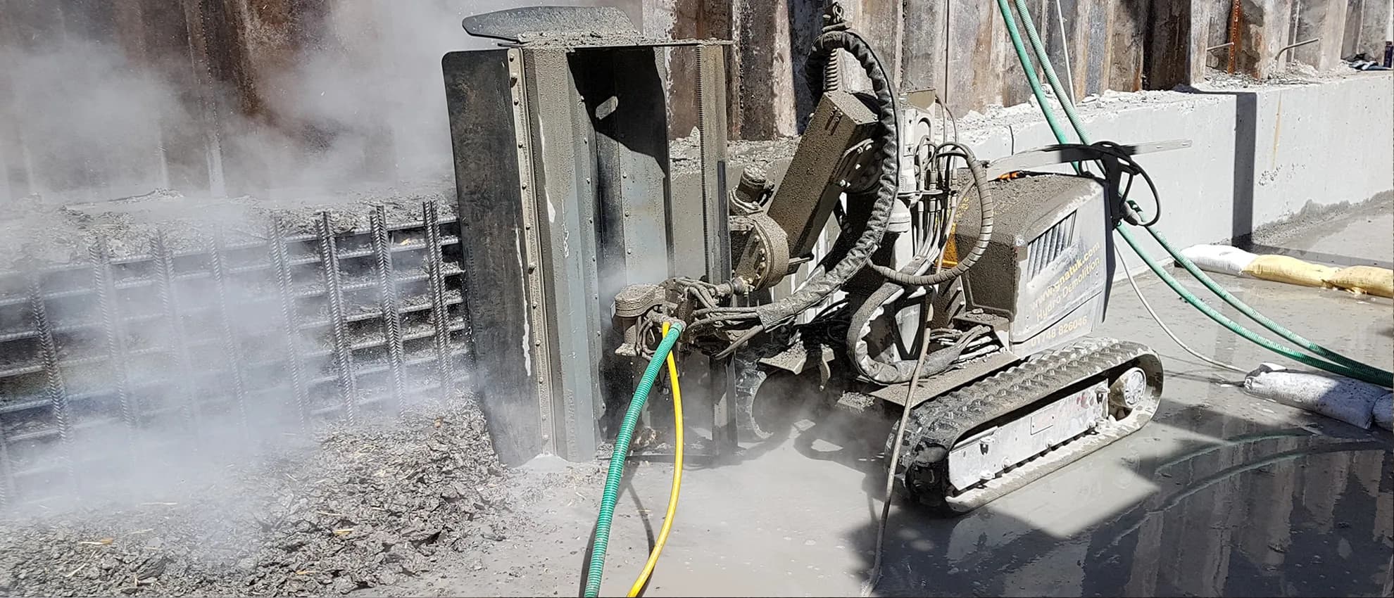High-pressure water lance removing deteriorated concrete from a reinforced structure during hydrodemolition works