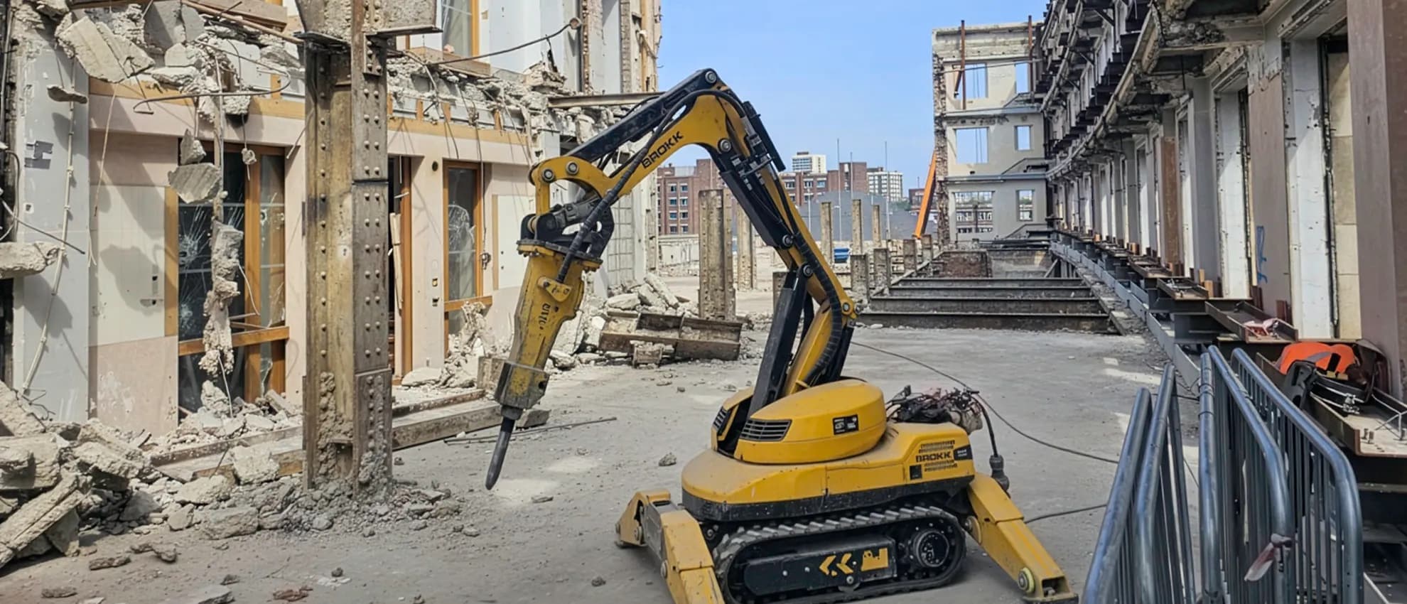 Remote-operated robotic demolition machine breaking out reinforced concrete in a confined live environment