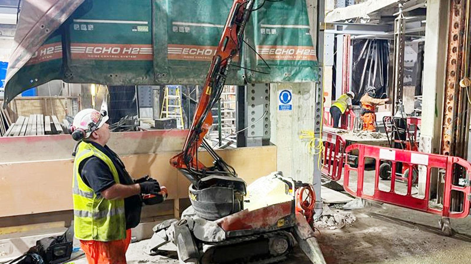 Husqvarna DXR140 robot with high-reach boom breaking out a basement ceiling in a confined space