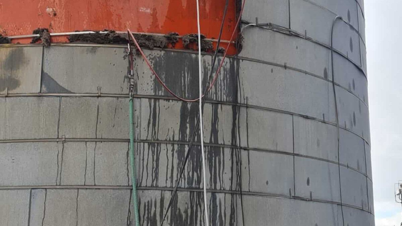 Brokk 800 Diesel robot removing solidified oil sludge from an oil storage tank after abrasive cold cutting access