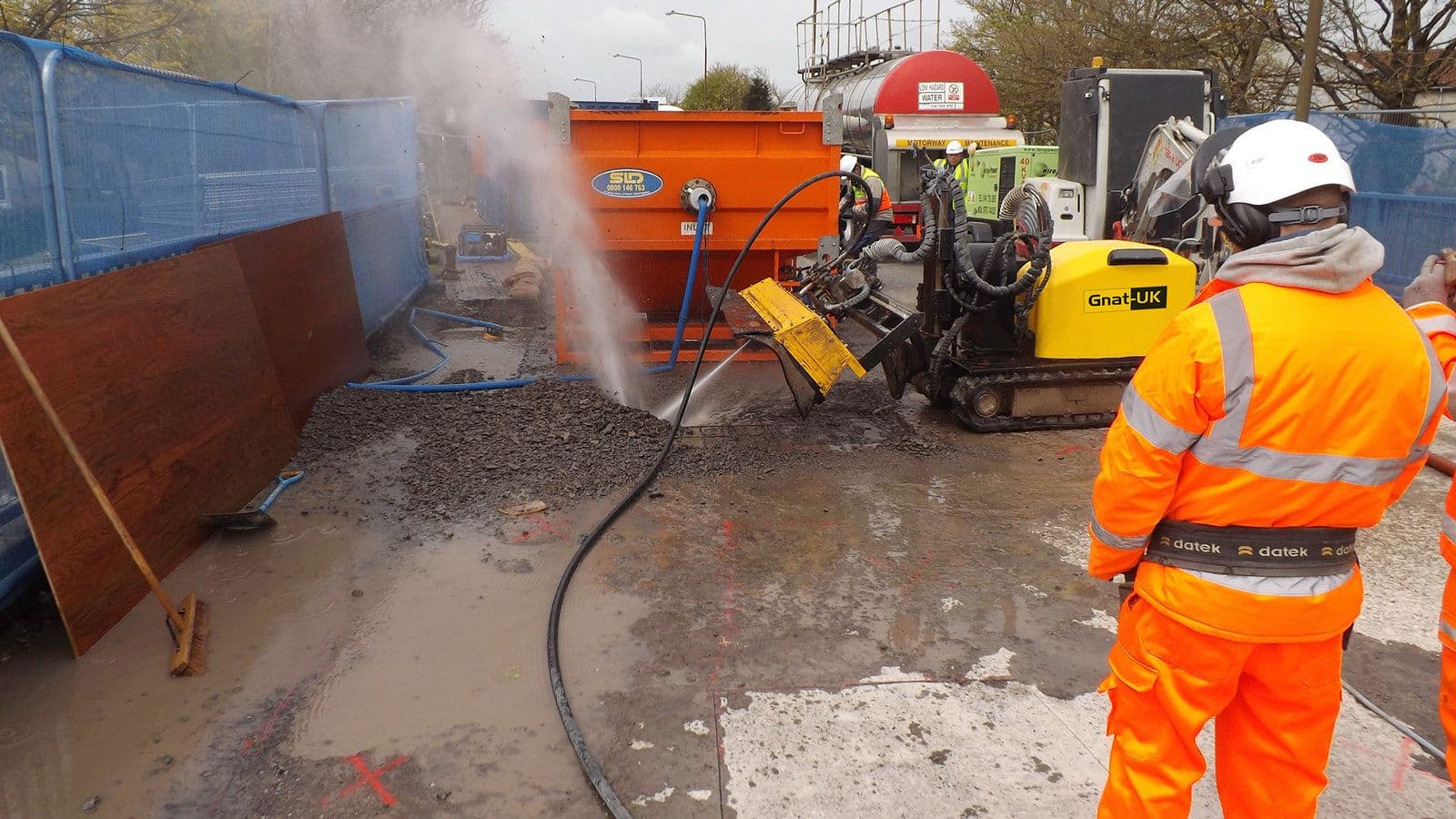 Robotic hydrodemolition equipment removing damaged concrete from a city bridge deck