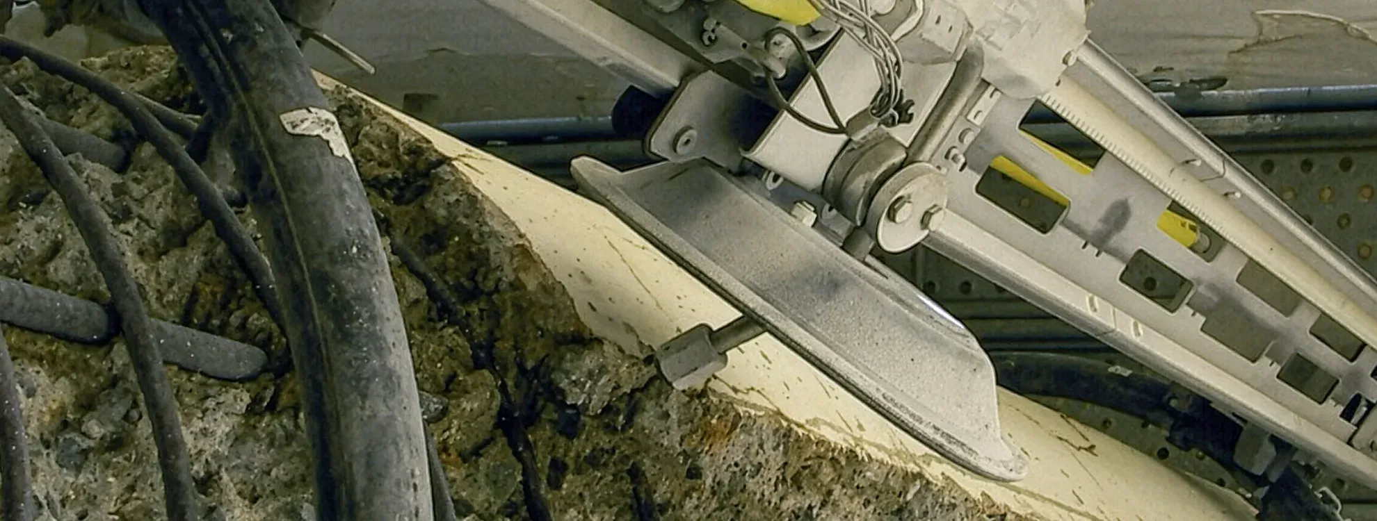 NALTA remote-controlled hydrodemolition lance close-up — the oscillating head working a concrete surface in a petrochemical environment